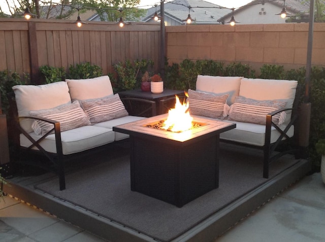 view of patio with a fenced backyard and an outdoor living space with a fire pit