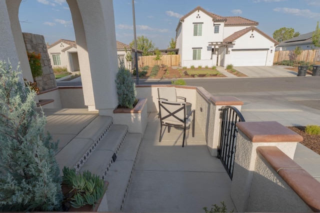 view of patio / terrace with fence, a residential view, and concrete driveway