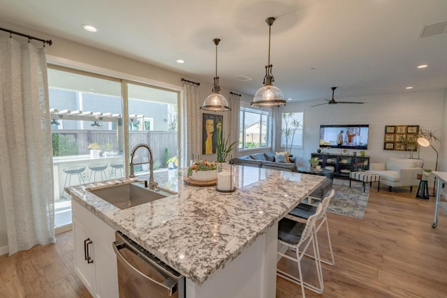 kitchen with visible vents, dishwasher, a sink, light wood-style floors, and white cabinetry
