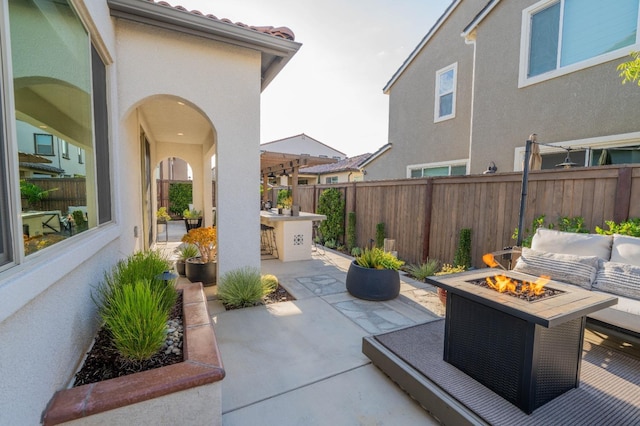 view of patio featuring a fenced backyard and an outdoor living space with a fire pit