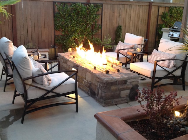 view of patio / terrace featuring an outdoor fire pit and fence