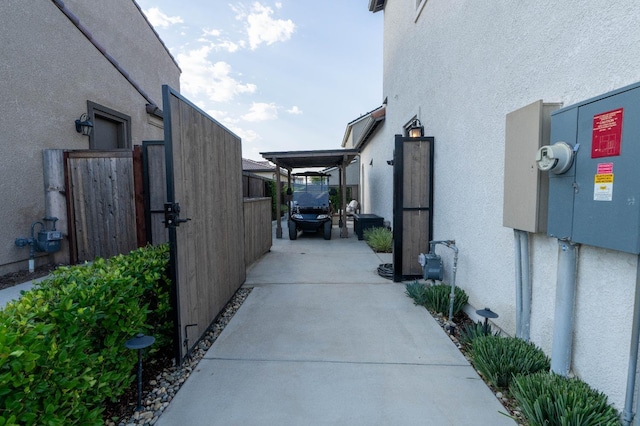view of side of property with stucco siding, fence, and a gate