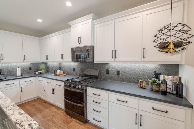 kitchen featuring white cabinets, range with two ovens, and light wood-style flooring
