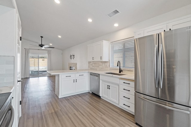 1125 N Purdue Ave, Clovis, CA 93611 - kitchen featuring stainless steel appliances, a sink, a peninsula, white cabinetry, and tasteful backsplash