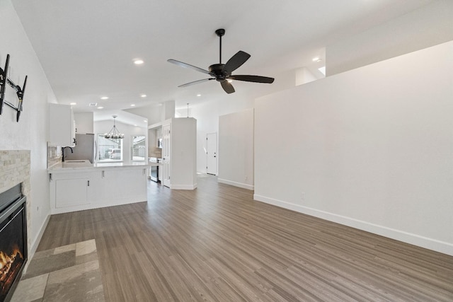 1125 N Purdue Ave, Clovis, CA 93611 - unfurnished living room with wood finished floors, a fireplace, recessed lighting, a chandelier, and a ceiling fan