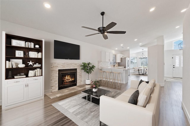 1125 N Purdue Ave, Clovis, CA 93611 - living area featuring vaulted ceiling, light wood-type flooring, ceiling fan, a fireplace, and recessed lighting