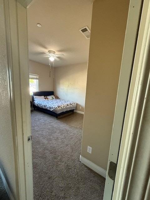 carpeted bedroom with baseboards, a ceiling fan, and visible vents