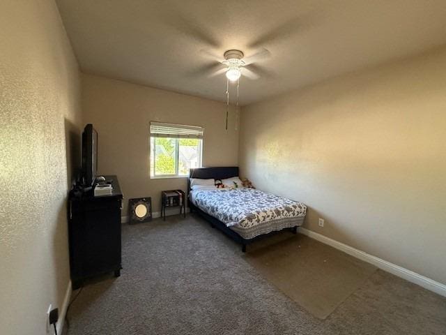 carpeted bedroom featuring baseboards and a ceiling fan