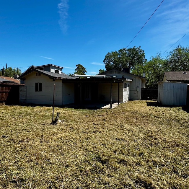 back of property with a yard and fence