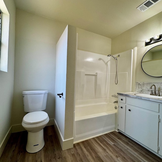 full bathroom with shower / washtub combination, vanity, visible vents, toilet, and wood finished floors
