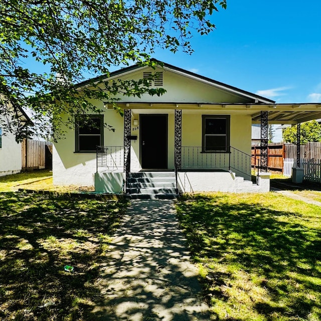 bungalow-style home with a porch, stucco siding, fence, and a front lawn