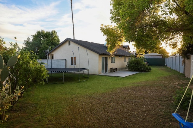 5157 E Truman Ave, Fresno, CA 93725 - back of house with a trampoline, stucco siding, and a patio