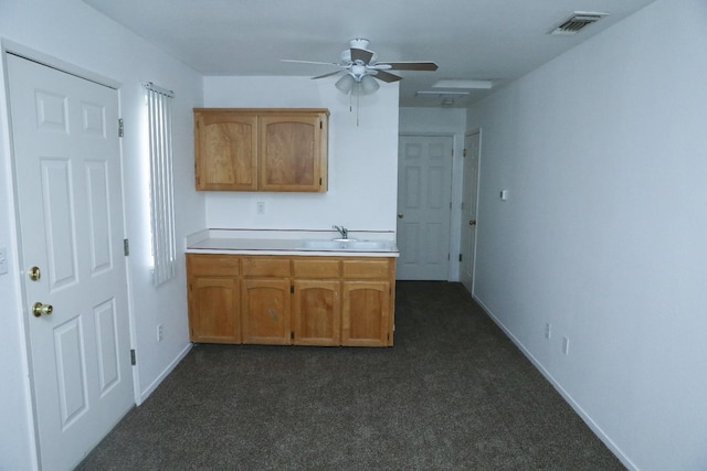 5157 E Truman Ave, Fresno, CA 93725 - kitchen with dark colored carpet, a ceiling fan, light countertops, baseboards, and brown cabinets