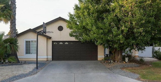 5157 E Truman Ave, Fresno, CA 93725 - view of front facade with a garage, driveway, stucco siding, and fence