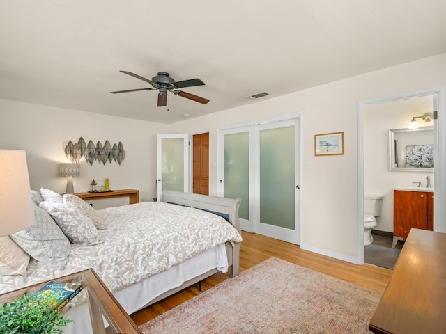 6043 N Forkner Ave, Fresno, CA 93711 - bedroom with wood finished floors, ensuite bath, baseboards, and a sink