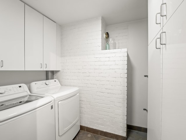 6043 N Forkner Ave, Fresno, CA 93711 - laundry area featuring washing machine and dryer, cabinet space, dark tile patterned floors, and brick wall