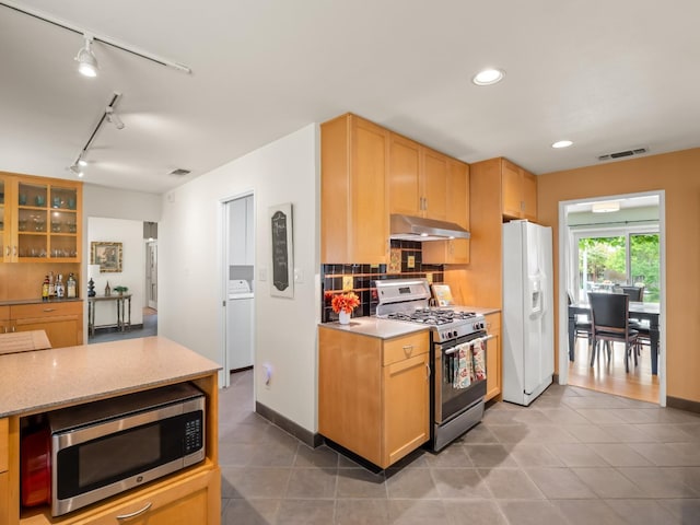 6043 N Forkner Ave, Fresno, CA 93711 - kitchen featuring stainless steel appliances, under cabinet range hood, rail lighting, washer / clothes dryer, and light tile patterned floors