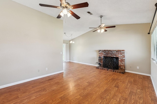 704 Rosehill Dr, Chowchilla, CA 93610 - unfurnished living room with vaulted ceiling, a fireplace, visible vents, ceiling fan, and wood finished floors
