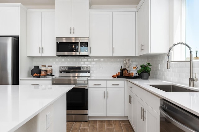1899 N Apricot Ave, Fresno, CA 93727 - kitchen with appliances with stainless steel finishes, a sink, light countertops, white cabinets, and backsplash