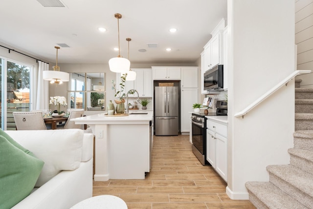 2110 N Brindac Ln, Clovis, CA 93619 - kitchen with appliances with stainless steel finishes, white cabinetry, light wood-style floors, light countertops, and recessed lighting