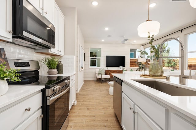 2110 N Brindac Ln, Clovis, CA 93619 - kitchen featuring stainless steel appliances, recessed lighting, white cabinets, light countertops, and light wood-style flooring