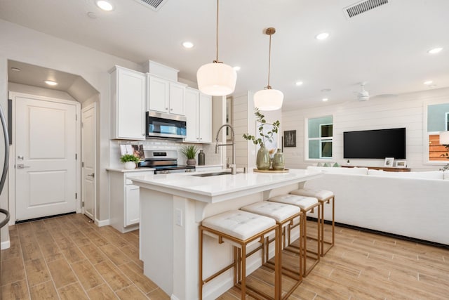 2110 N Brindac Ln, Clovis, CA 93619 - kitchen featuring stainless steel appliances, open floor plan, light wood-style floors, white cabinetry, and recessed lighting