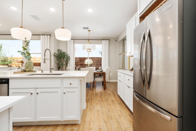 2110 N Brindac Ln, Clovis, CA 93619 - kitchen featuring stainless steel appliances, light countertops, white cabinets, light wood finished floors, and recessed lighting