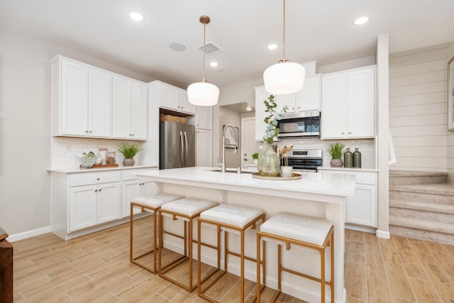 2110 N Brindac Ln, Clovis, CA 93619 - kitchen featuring appliances with stainless steel finishes, light wood-type flooring, tasteful backsplash, light countertops, and recessed lighting