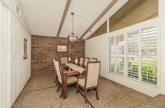 dining space featuring a textured ceiling, brick wall, an inviting chandelier, and lofted ceiling with beams