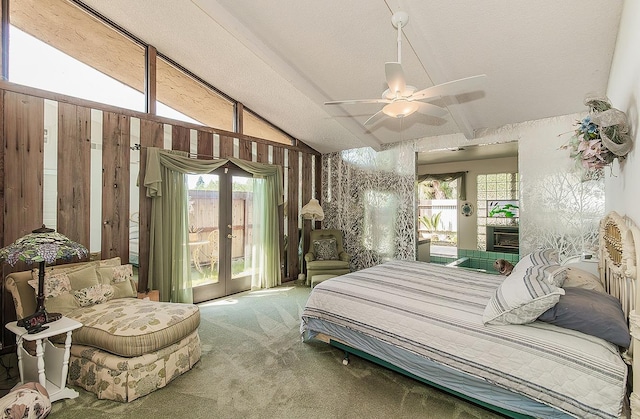 bedroom featuring vaulted ceiling, a fireplace, french doors, carpet floors, and access to exterior