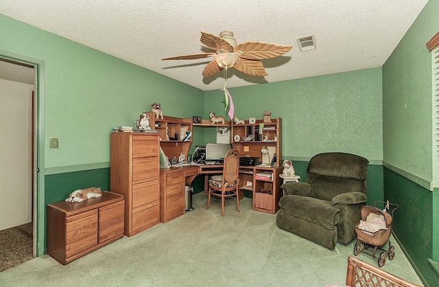 office featuring visible vents, ceiling fan, light colored carpet, and a textured ceiling