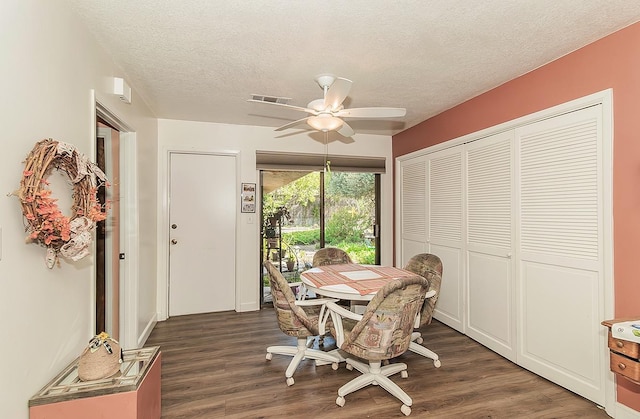 dining area with dark wood-style flooring, a textured ceiling, and ceiling fan