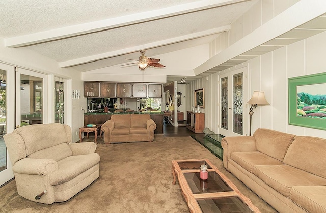 carpeted living area featuring ceiling fan, a textured ceiling, vaulted ceiling with beams, and a healthy amount of sunlight