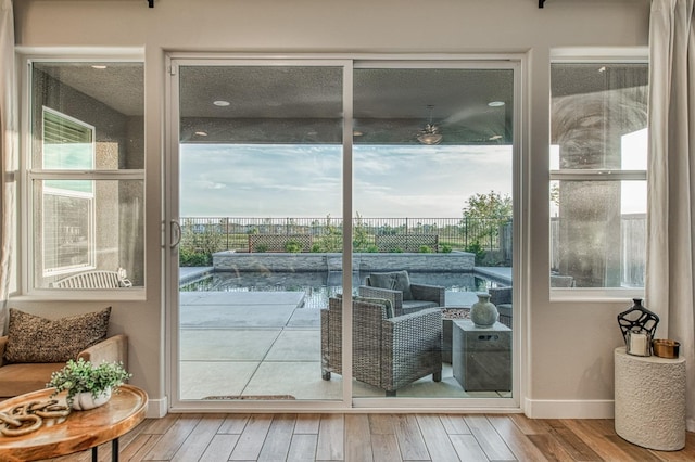 doorway to outside featuring baseboards and hardwood / wood-style floors