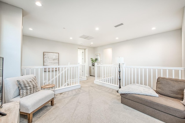 sitting room with visible vents, an upstairs landing, carpet floors, and recessed lighting