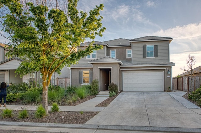 view of front of house featuring fence, a garage, stucco siding, and concrete driveway