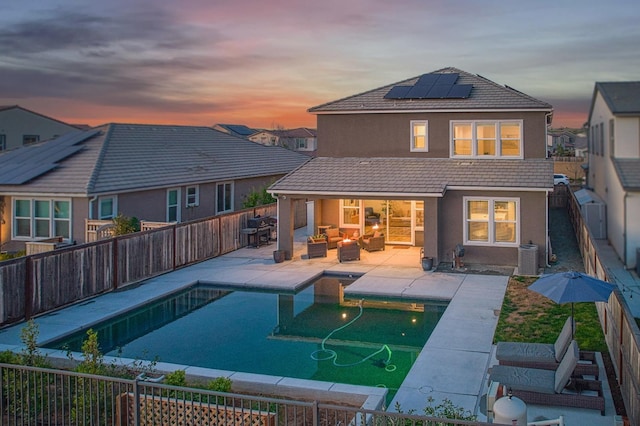 rear view of property featuring an outdoor living space, a tiled roof, and a fenced backyard
