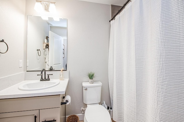 bathroom with toilet, vanity, and curtained shower