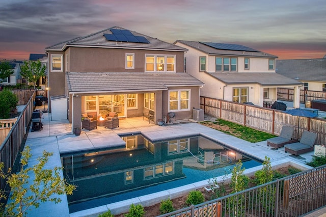 rear view of house featuring a fenced backyard, a patio area, solar panels, and an outdoor living space