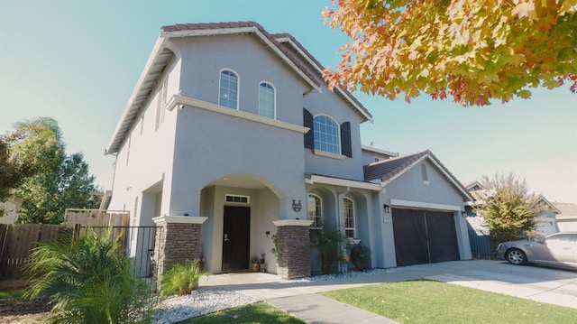 view of front of property with driveway, stucco siding, a tiled roof, and fence