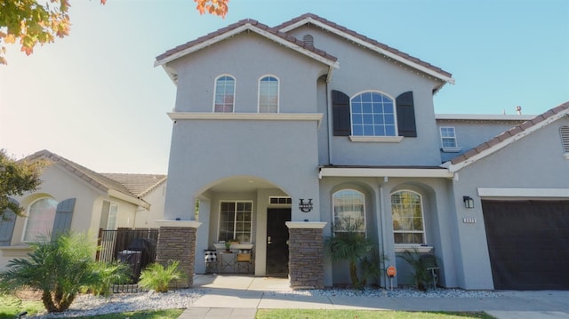 mediterranean / spanish-style home with stucco siding and a tile roof