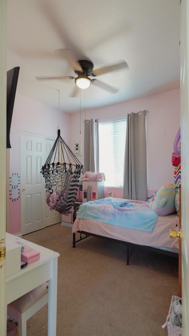 bedroom with a ceiling fan and carpet