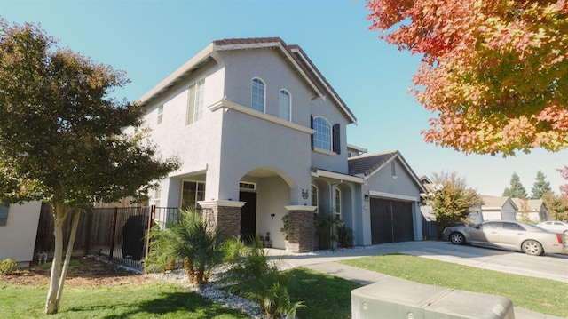 traditional-style home featuring stone siding, a tile roof, fence, stucco siding, and driveway