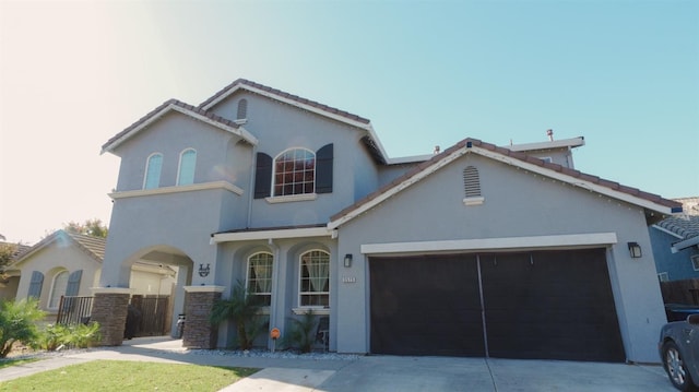 view of front of house featuring a tiled roof, concrete driveway, stucco siding, and a garage