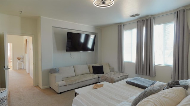living area with visible vents and light colored carpet