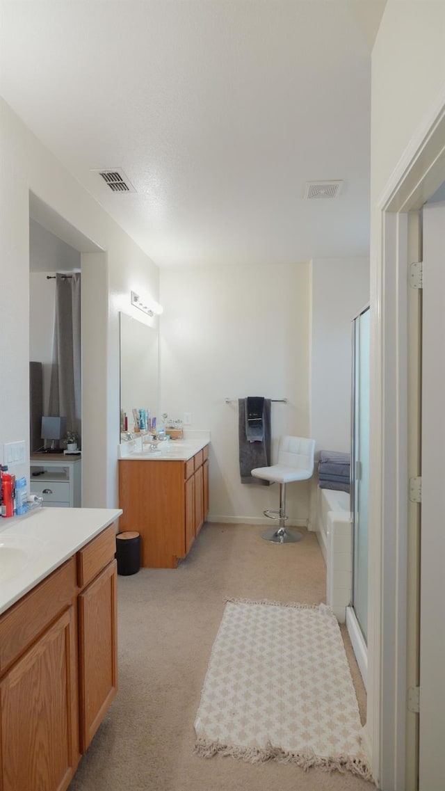 bathroom with a sink, visible vents, two vanities, and a shower stall