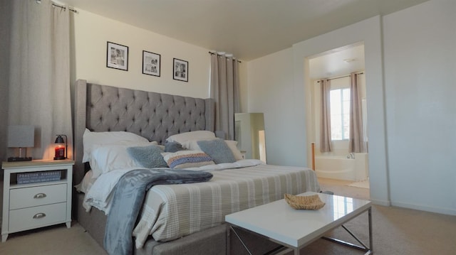 bedroom featuring light carpet, ensuite bath, and baseboards