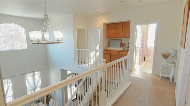 hall with light colored carpet, an inviting chandelier, an upstairs landing, and recessed lighting