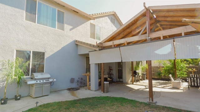 rear view of property with a patio, stucco siding, and fence