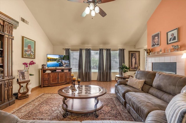 6305 N Marty Ave, Fresno, CA 93711 - living room featuring high vaulted ceiling, a fireplace, light wood-type flooring, a ceiling fan, and visible vents
